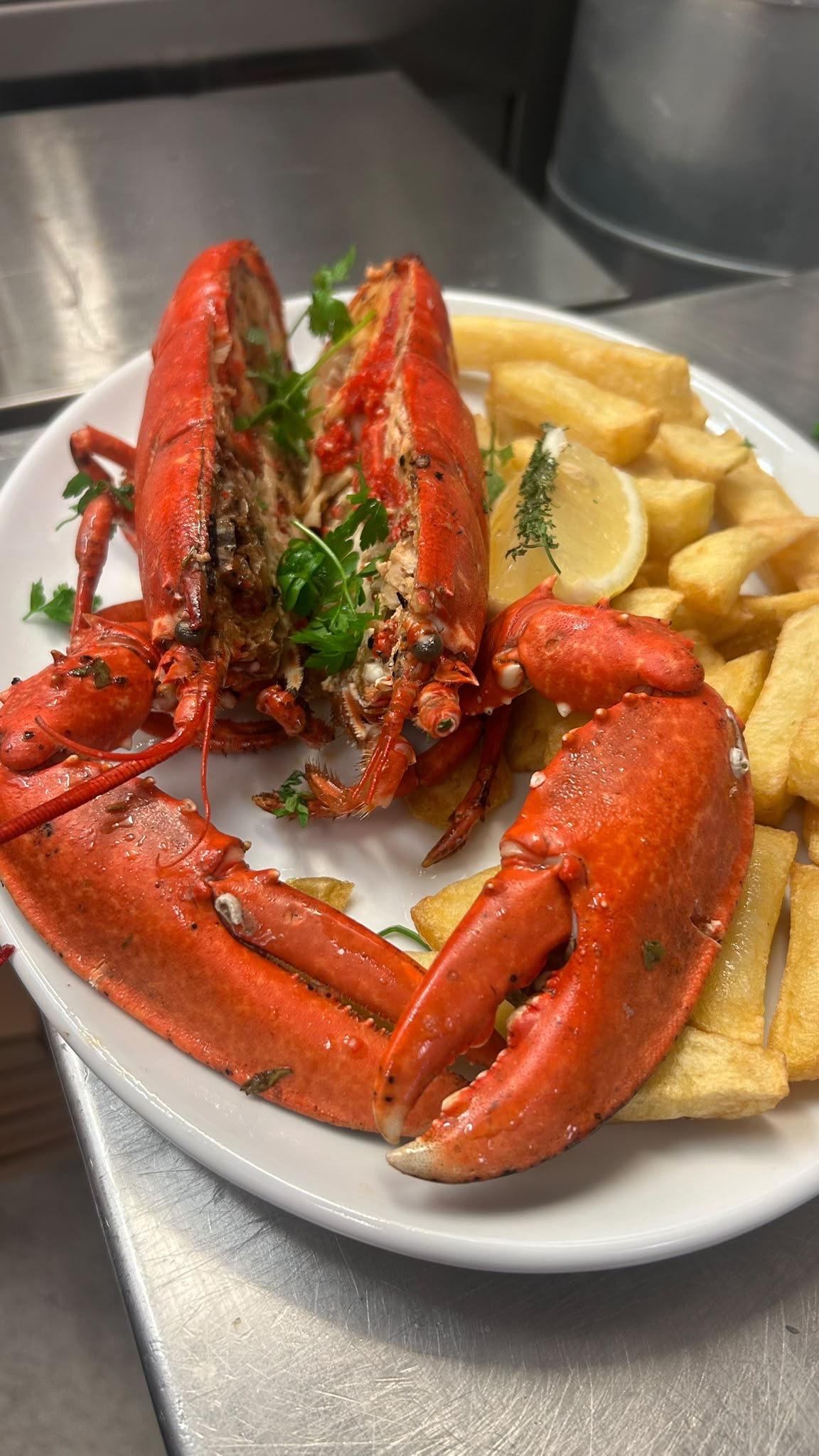Grilled lobster served with chips and lemon